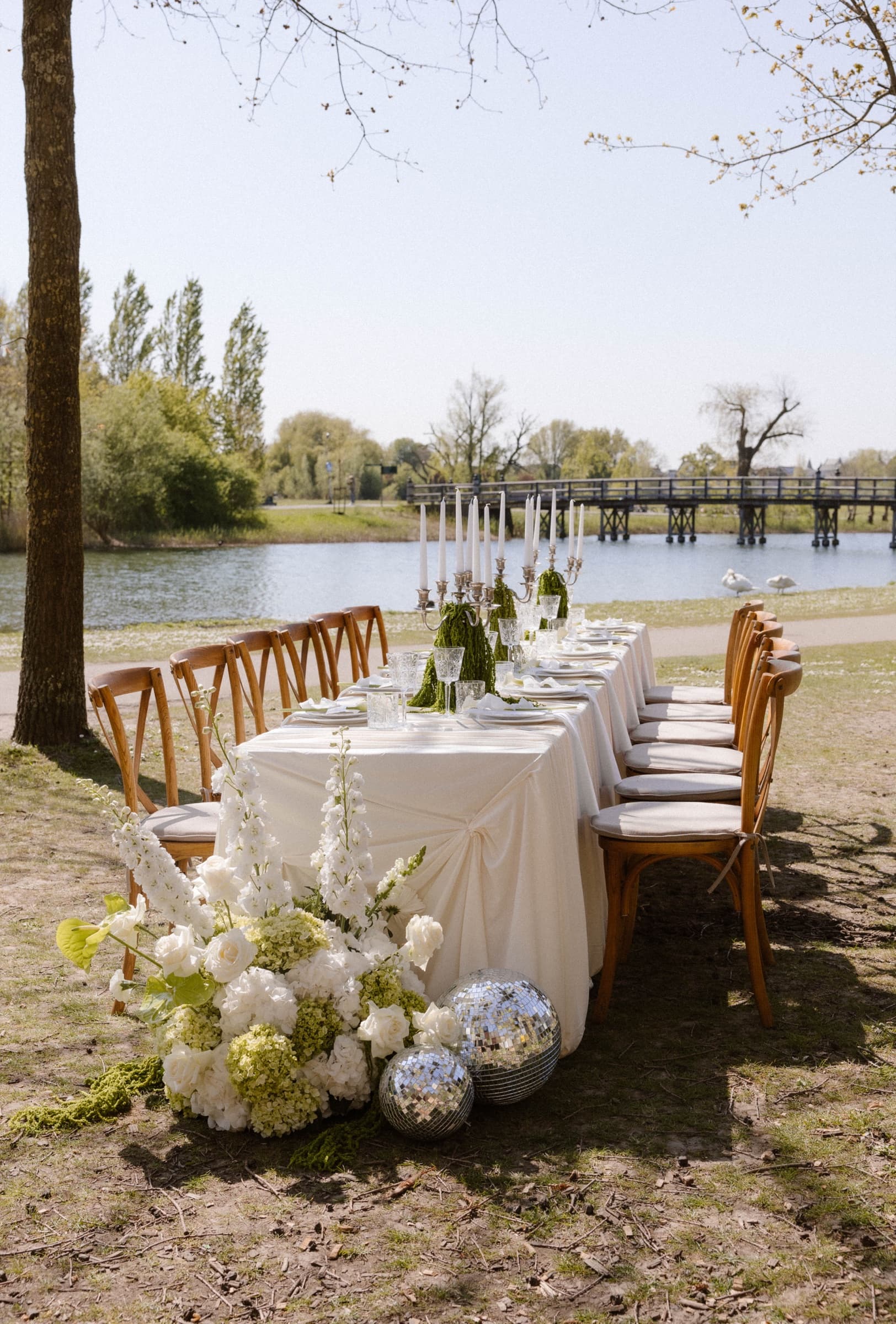 Bruiloft diner aan het water met discoballen en bloemen