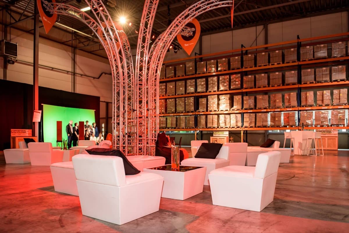 Truss-installatie met witte loungebanken en sfeerverlichting